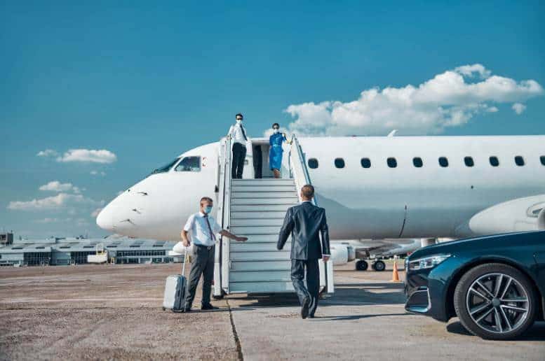 A group of business men and women are boarding a car service to Newark Airport from NJ.