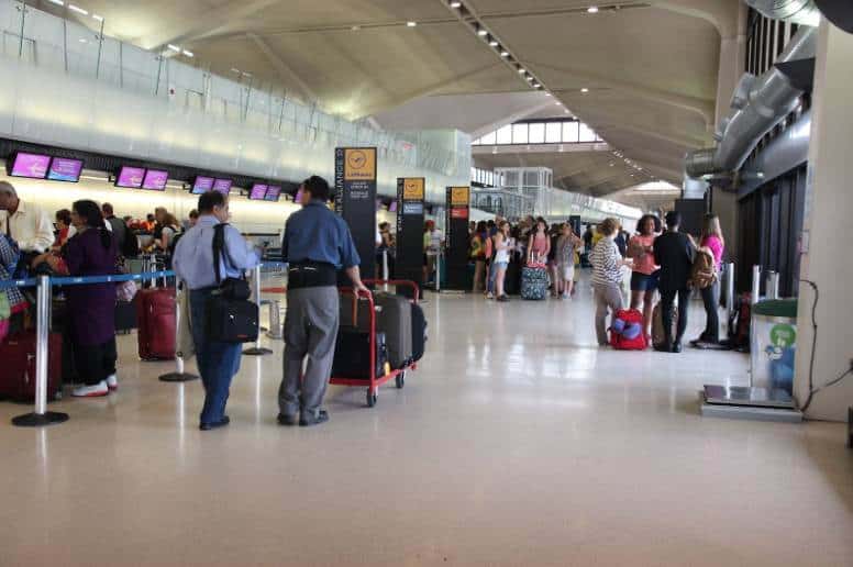 A group of people waiting in line at Newark Airport for transportation.