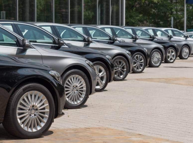 A row of Mercedes-Benz cars parked in front of a building, possibly used for Newark Airport transportation.