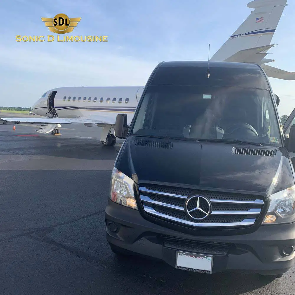Sonic D Limousine's black Mercedes Sprinter parked next to an airplane provides transportation from Hackensack to Newark Airport.