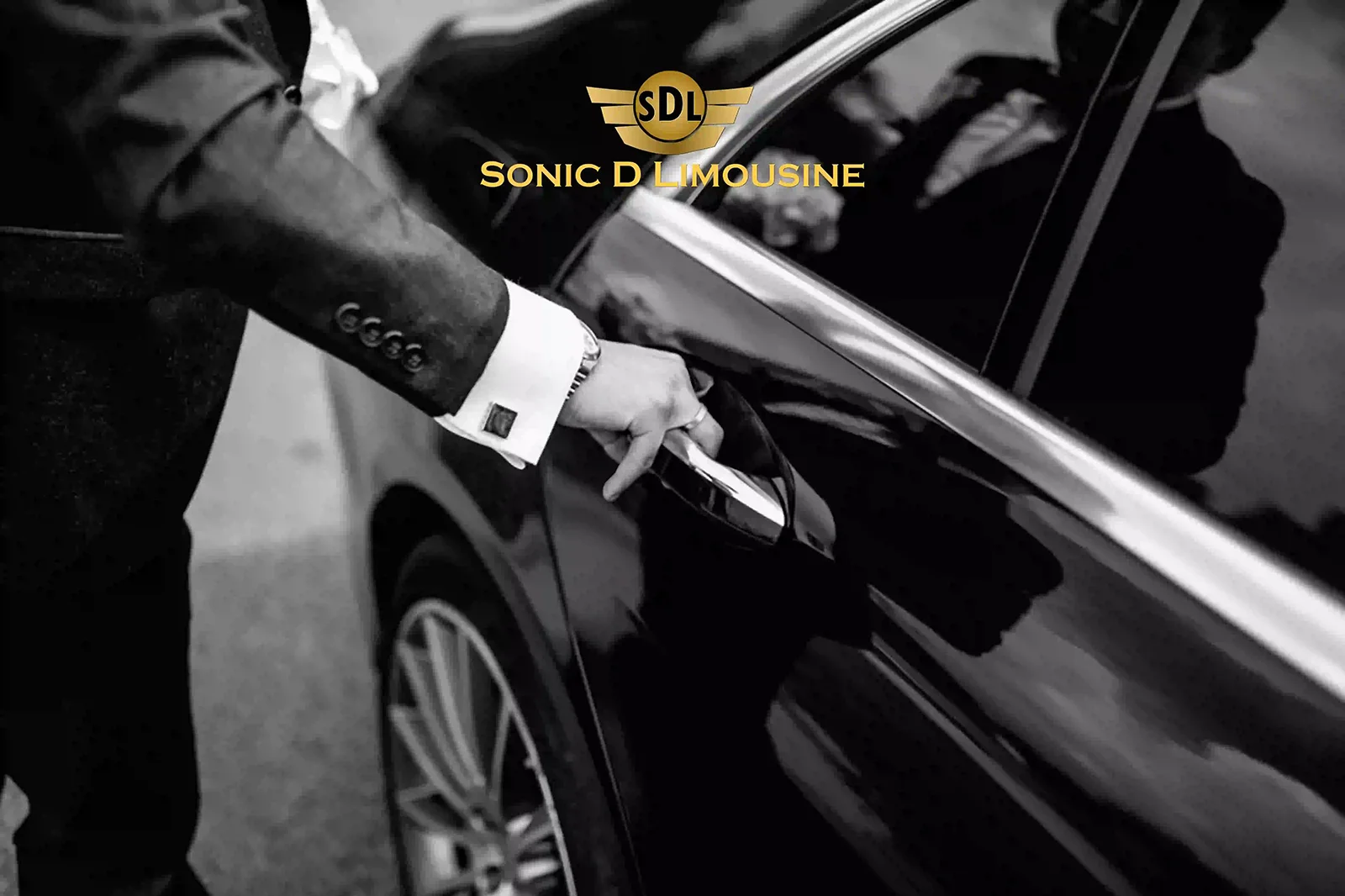 Sonic D Limousine A man in a suit is opening the door of a black car.