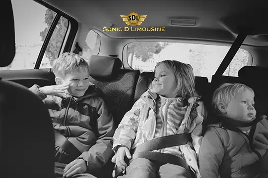 Sonic D Limousine Worldwide Voted Most Reliable Airport Transportation Provider! Three children sitting in the back seat of a car, two are smiling and interacting, while the third looks ahead. The Sonic D Limousine Luxury Airport Transportation logo is displayed at the top. Sonic D Limousine Worldwide your luxury Airport Transportation