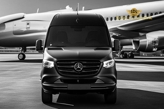 Sonic D Limousine Worldwide Voted Most Reliable Airport Transportation Provider! A black Mercedes-Benz van from Sonic D Limousine Luxury Airport Transportation is parked in front of a large airplane on the airport runway; the logo for SDL Sonic D Limousine is prominently displayed in the upper right corner. Sonic D Limousine Worldwide your luxury Airport Transportation