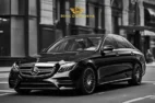 Sonic D Limousine Worldwide Voted Most Reliable Airport Transportation Provider! A black Mercedes-Benz sedan, emblazoned with the "Sonic D Limousine Luxury Airport Transportation" logo, is parked on a city street. Sonic D Limousine Worldwide your luxury Airport Transportation