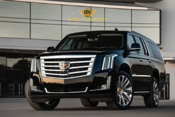 Sonic D Limousine Worldwide Voted Most Reliable Airport Transportation Provider! A black Cadillac Escalade is parked in front of a modern building with the Sonic D Limousine logo displayed above, showcasing their luxury airport transportation services. Sonic D Limousine Worldwide your luxury Airport Transportation